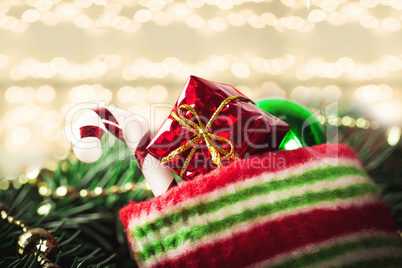 Christmas sock with toys and gifts on wooden background with Christmas tree