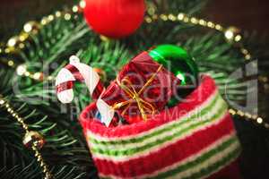 Christmas sock with toys and gifts on wooden background with Christmas tree