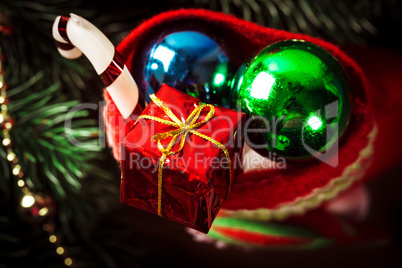 Christmas sock with toys and gifts on wooden background with Christmas tree