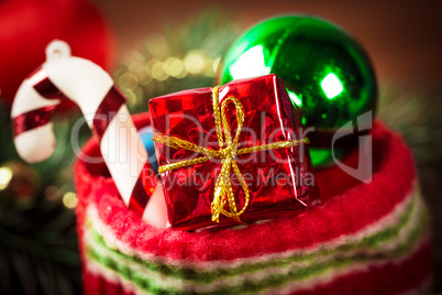 Christmas sock with toys and gifts on wooden background with Christmas tree