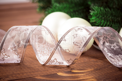 Christmas background with white ribbon and Christmas balls on wooden background