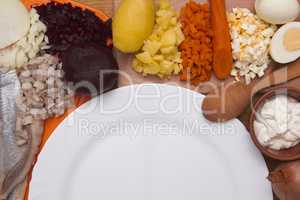 Ingredients for the herring salad with an empty plate