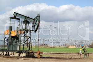 oil field with pumpjack and oil worker