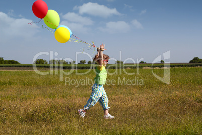 little girl running with balloons