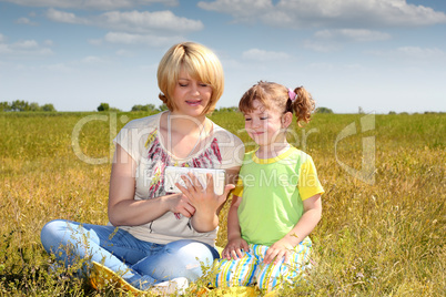 mother and daughter playing with tablet