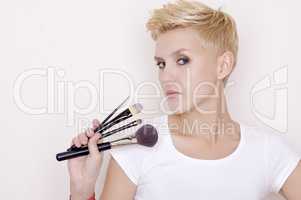 Make-up artist holding brushes