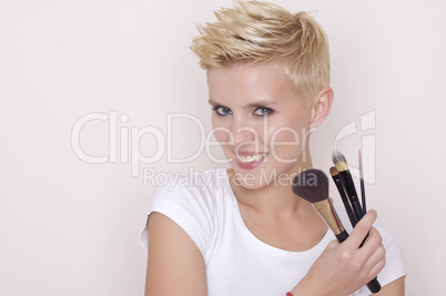 Make-up artist holding brushes