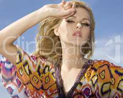 beautiful blonde girl on background blue sky