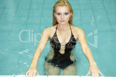 beautiful young woman standing in a swimming pool