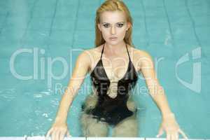 beautiful young woman standing in a swimming pool