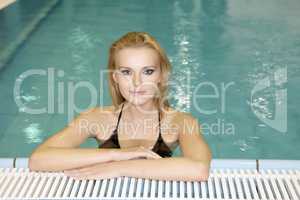 beautiful young woman standing in a swimming pool