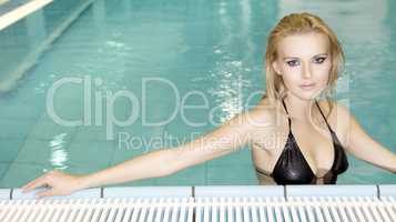 beautiful young woman standing in a swimming pool