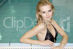 beautiful young woman standing in a swimming pool