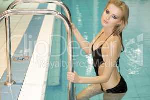 beautiful young woman standing in a swimming pool