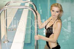 beautiful young woman standing in a swimming pool