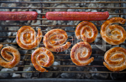 Grilling sausages on barbecue grill.
