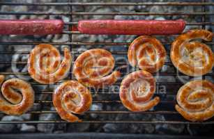 Grilling sausages on barbecue grill.