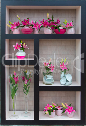 Lilies in vases stand on shelves