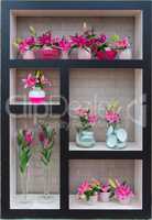 Lilies in vases stand on shelves