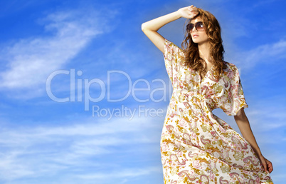 beautiful girl in sunglasses on background blue sky