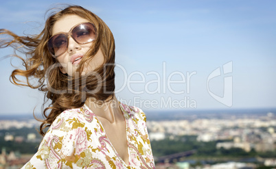 beautiful girl in sunglasses on background blue sky