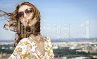 beautiful girl in sunglasses on background blue sky