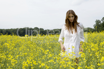 brunette woman in a yellow flowers field