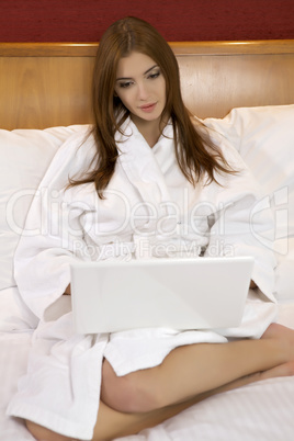 Portrait of beautiful woman with laptop on bed