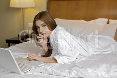 Portrait of beautiful woman with laptop on bed