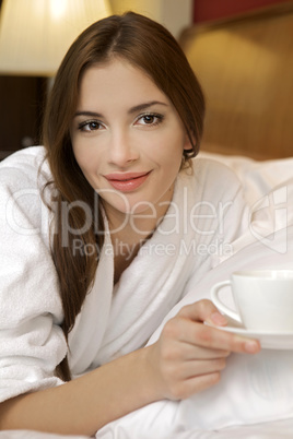 Closeup portrait of a happy young beautiful woman with a white c