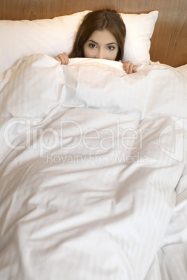 Above view of sleeping beautyful smiling brunet girl under white