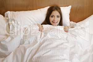 Beautiful woman is resting on white bed