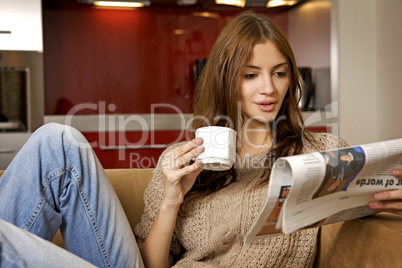 mid adult woman drinking coffee and reading news