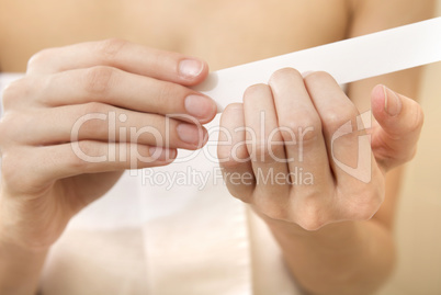 Woman polishing fingernails with the nail file