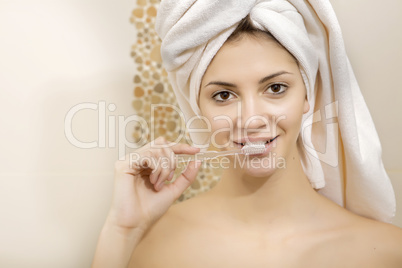 young beautiful woman brushing her teeth