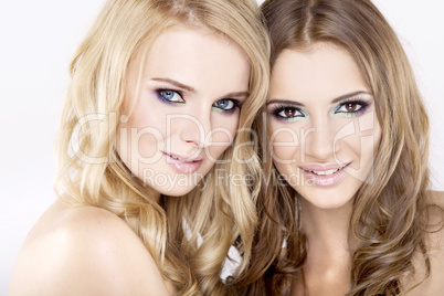 Two smiling girl friends - blond and brunette