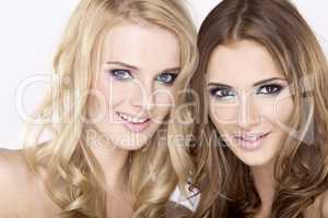 Two smiling girl friends - blond and brunette