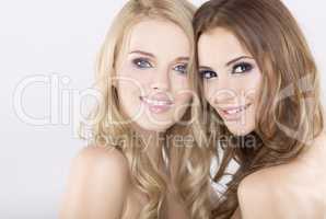 Two smiling girl friends - blond and brunette