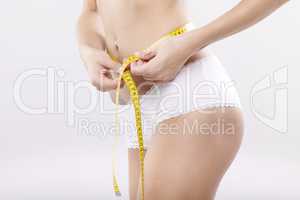 Beautiful sporty woman with yellow measure around body