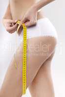 Beautiful sporty woman with yellow measure around body