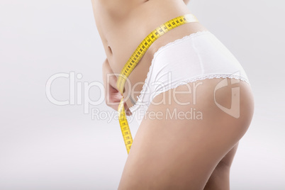 Beautiful sporty woman with yellow measure around body