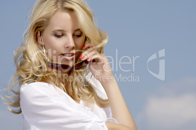 beautiful girl in sunglasses on background blue sky