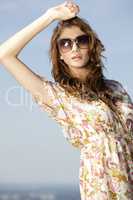 beautiful girl in sunglasses on background blue sky