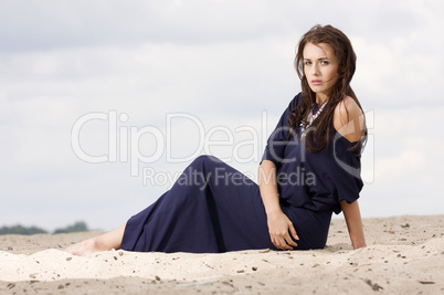 Sexy brunette posing in violet dress.