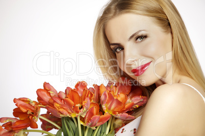 Beautiful blonde girl with the bouquet of tulips isolated on a w