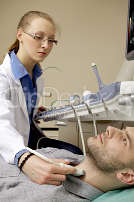 Portrait of young female technician operating ultrasound machine