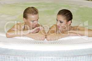 Two young beautiful girls in jacuzzi