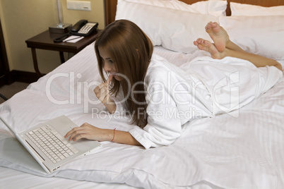 Portrait of beautiful woman with laptop on bed