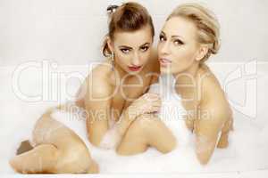 Two attractive woman in bath relaxing.