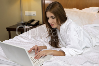 Portrait of beautiful woman with laptop on bed